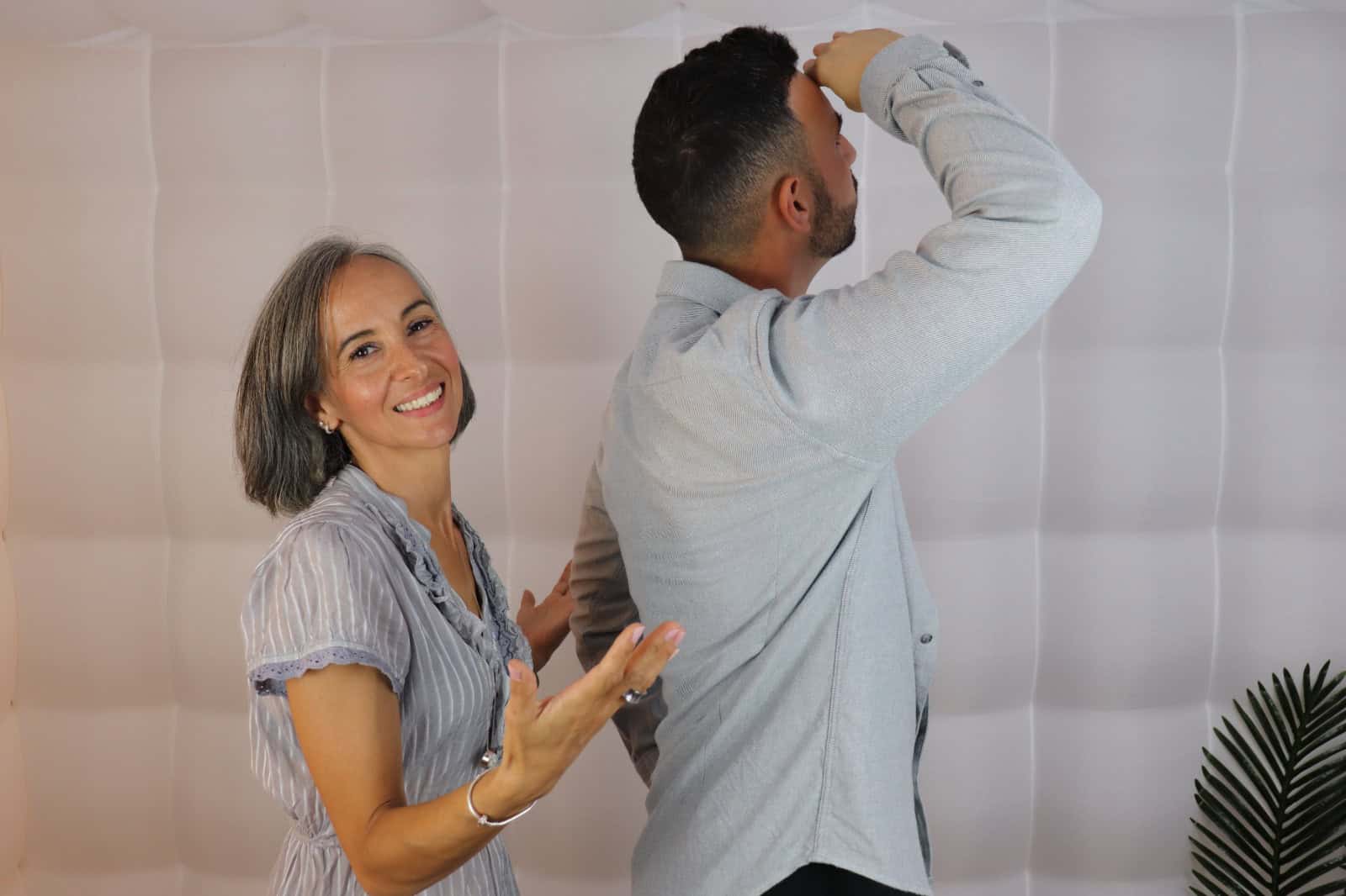 Two people inspecting a wall, one looking closely with a magnifying glass.